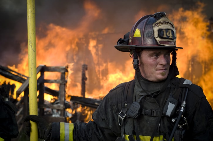 Photo of firefighter in full protective gear preparing to battle a blaze